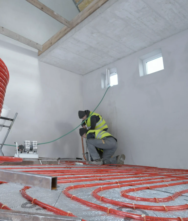 Pracownicy kładący ogrzewanie podłogowe